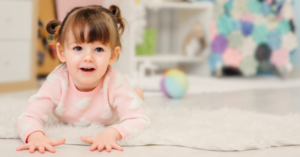 niña de 2 años acostada en la alfombra